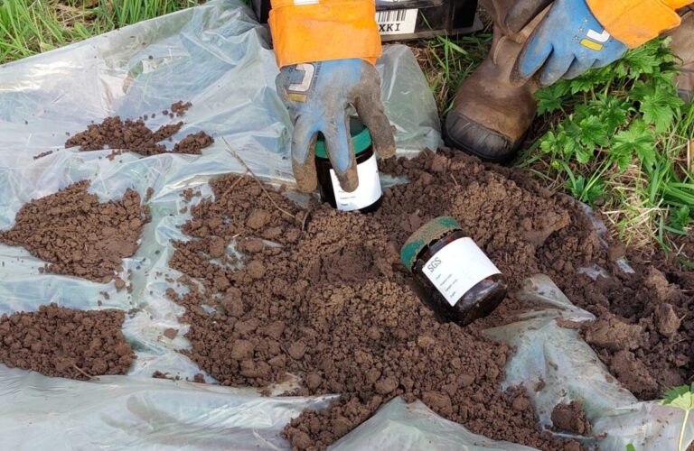 Veldwerker neemt grondmonsters voor bodemonderzoek