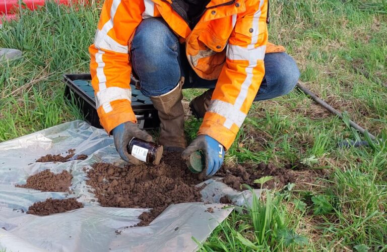 Veldwerker neemt een grondmonster voor bodemonderzoek