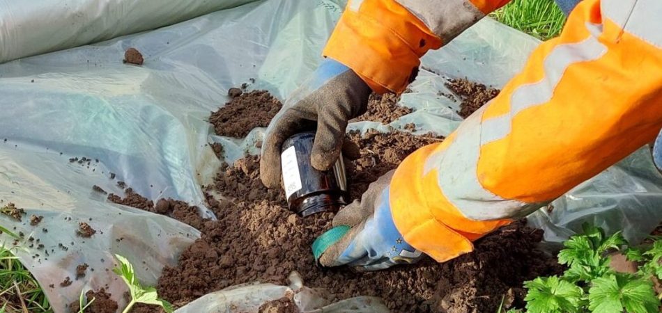 Veldwerker neemt een grondmonster voor bodemonderzoek