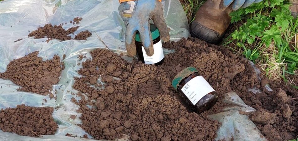 Veldwerker neemt grondmonsters voor bodemonderzoek